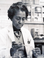 Marie Daly, and African American woman wearing a white lab coat holds a pipette
